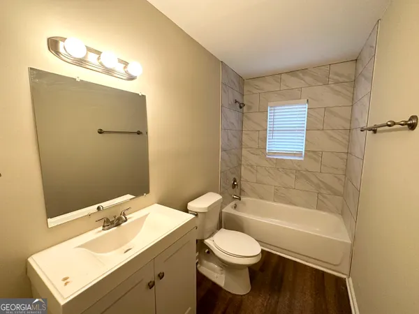 a bathroom with a bathtub shower sink vanity and toilet