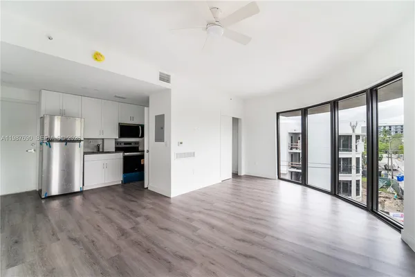 a kitchen with stainless steel appliances a refrigerator and wooden floor