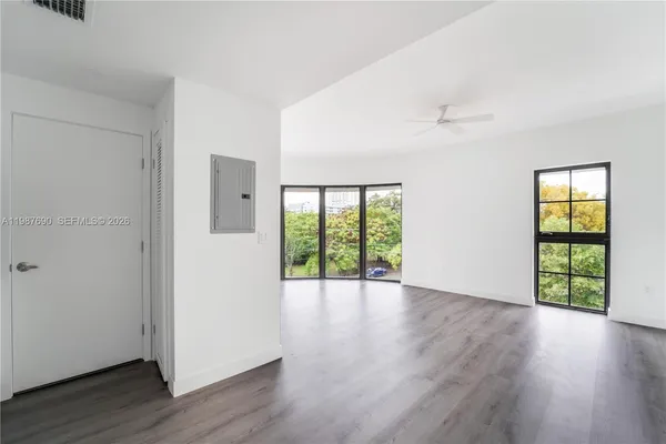 an empty room with wooden floor and windows