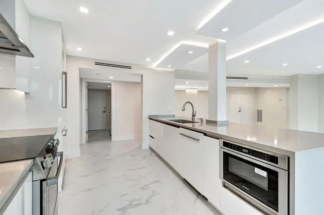 a large white bathroom with a large mirror vanity and shower