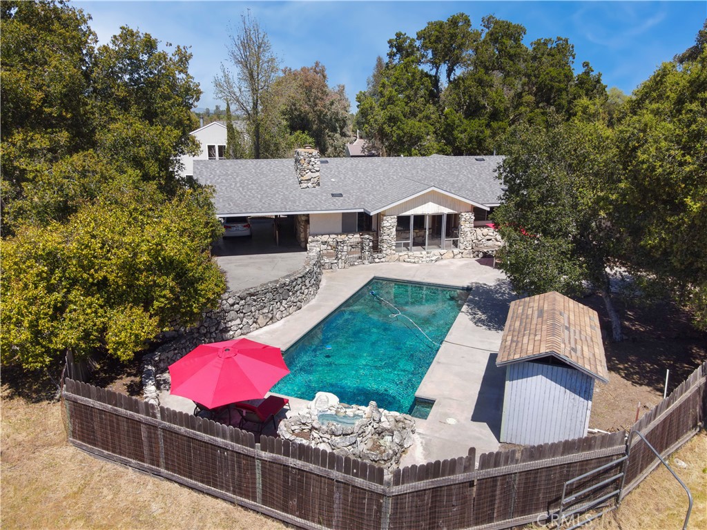 an aerial view of a house roof deck and yard with swimming pool