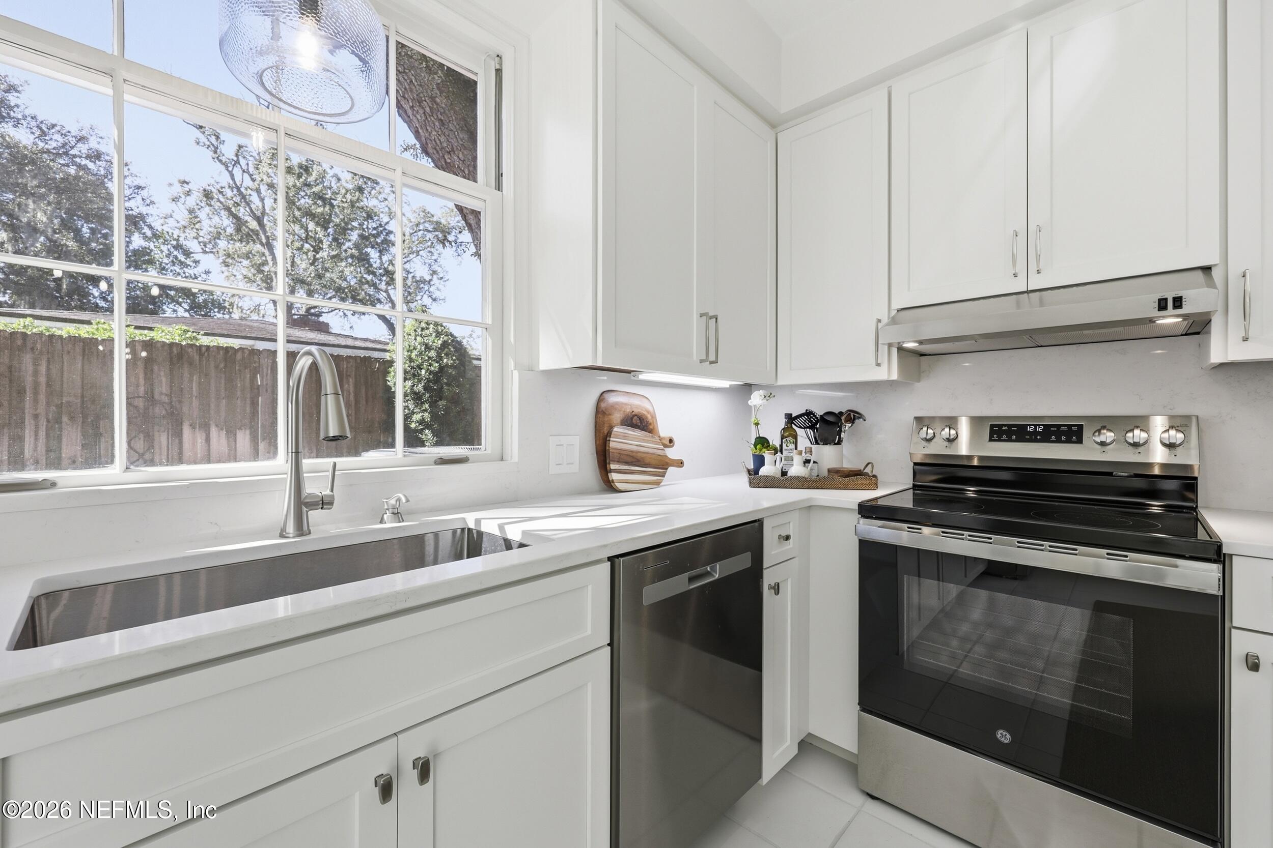 4706 Ivanhoe Road Jacksonville, FL 32210 - Photo 16 of 47 a kitchen with stainless steel appliances granite countertop a sink and a stove