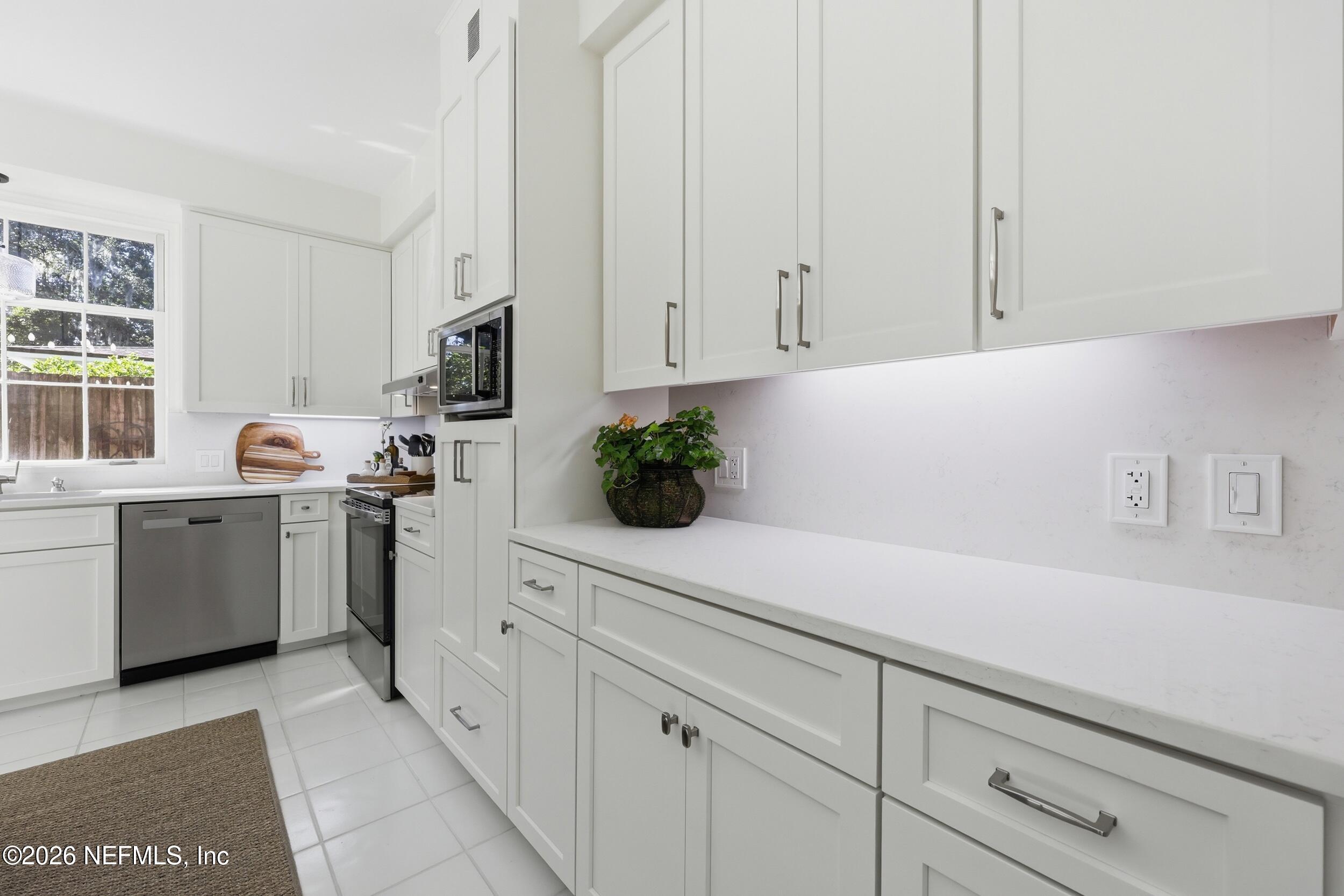4706 Ivanhoe Road Jacksonville, FL 32210 - Photo 17 of 47 a kitchen with white cabinets and white appliances