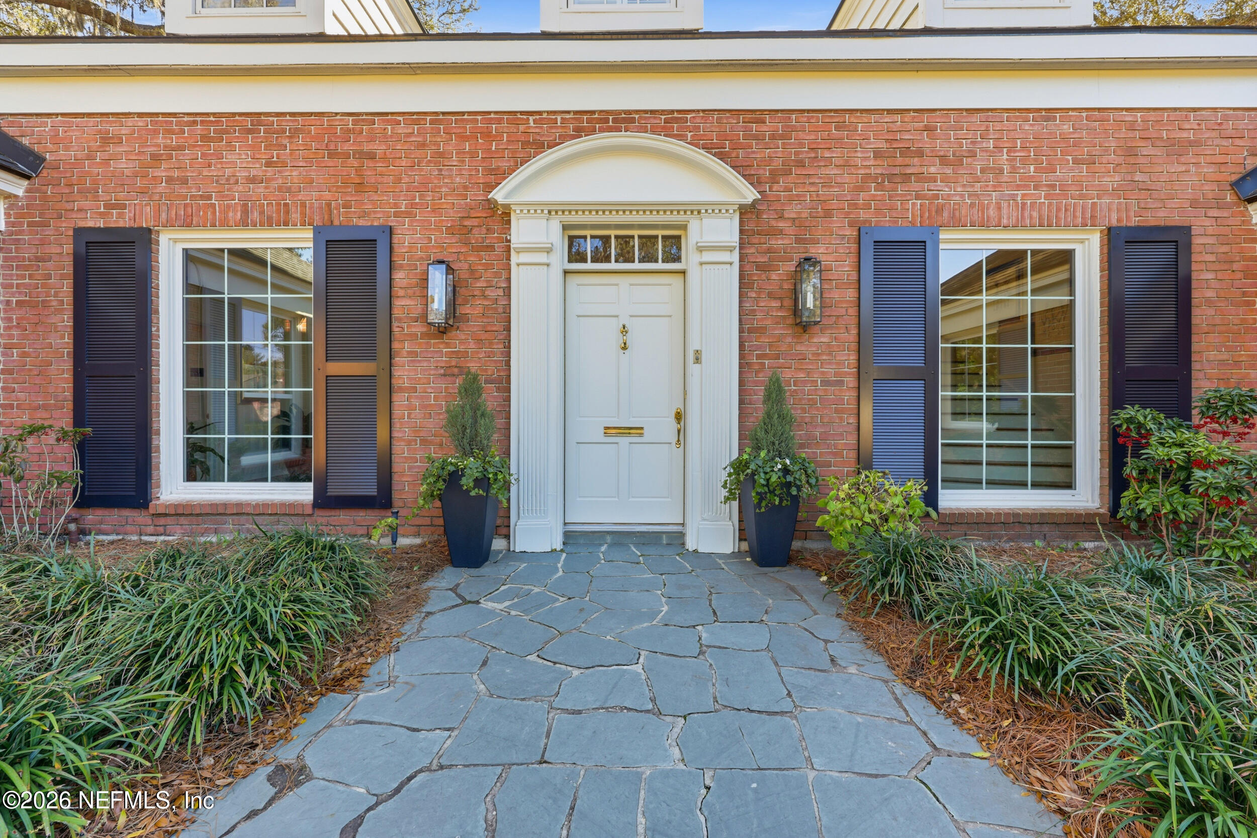 4706 Ivanhoe Road Jacksonville, FL 32210 - Photo 2 of 47 a view of a brick house with potted plants