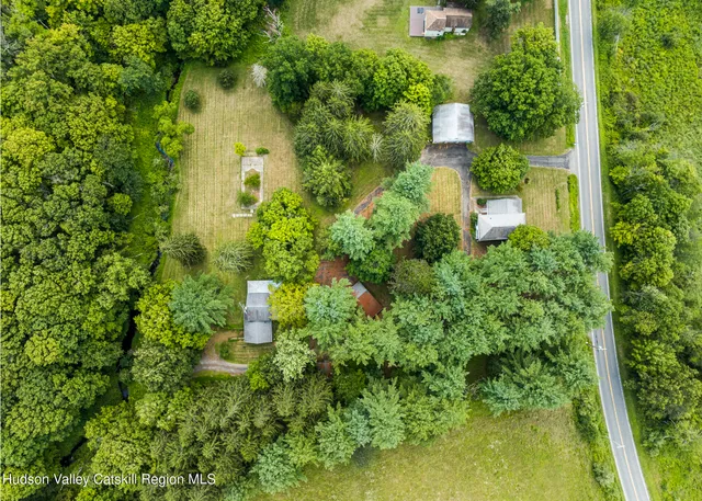 an aerial view of residential house with outdoor space and trees all around