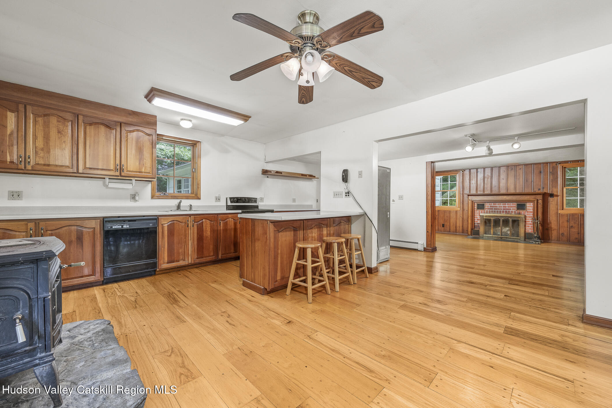 174 Co Rte 11 Pine Plains, NY 12567 - Photo 11 of 37 a open kitchen with stainless steel appliances kitchen island granite countertop a stove top oven a dining table and chairs with wooden floor