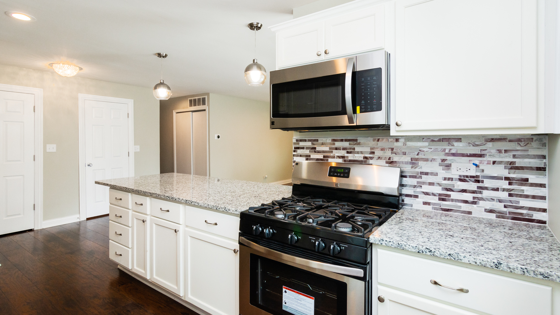 187 Queenswood Road Bolingbrook, IL 60440 - Photo 15 of 36 a kitchen with stainless steel appliances granite countertop a stove and a microwave