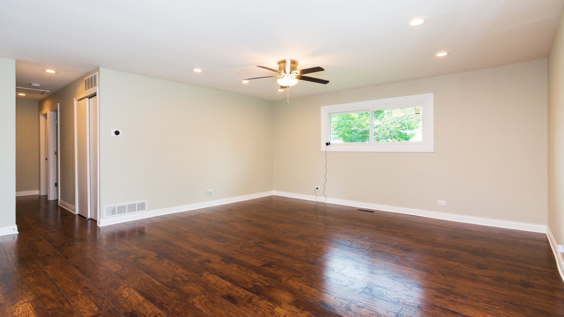 187 Queenswood Road Bolingbrook, IL 60440 - Photo 19 of 36 an empty room with wooden floor chandelier fan and windows