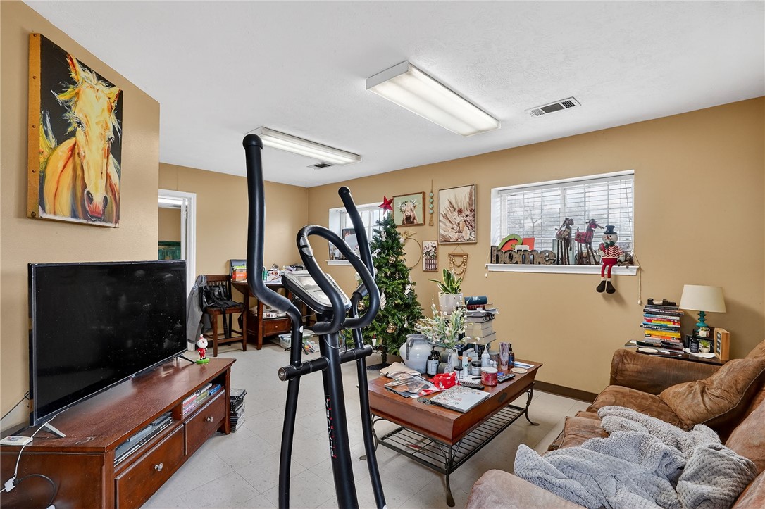 8601 Sandy Point Road Bryan, TX 77807 - Photo 16 of 50 a living room with furniture a flat screen tv and a wall painting