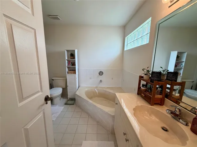 a bathroom with a tub sink and mirror