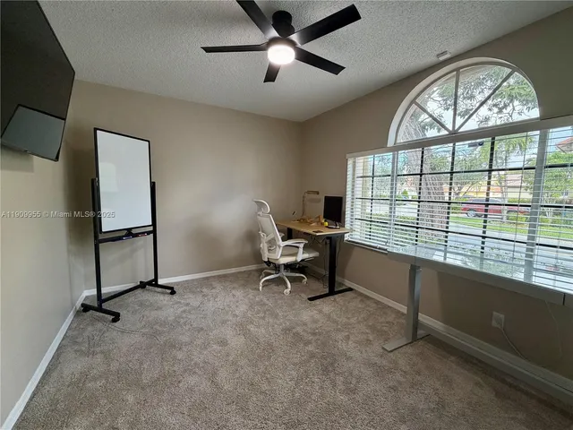 a view of a workspace with furniture and a window