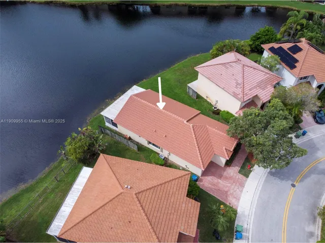 an aerial view of a house with a garden and lake view
