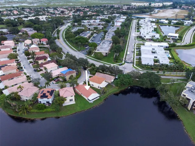 an aerial view of a house with a garden and lake view