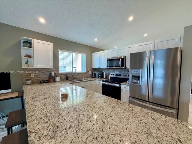 a kitchen with a refrigerator sink and microwave