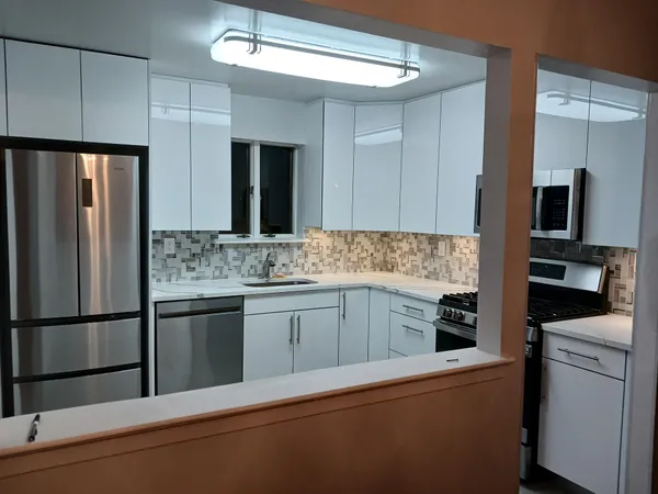 a kitchen with stainless steel appliances granite countertop a refrigerator sink and stove