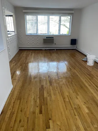 a view of a room with wooden floor and window