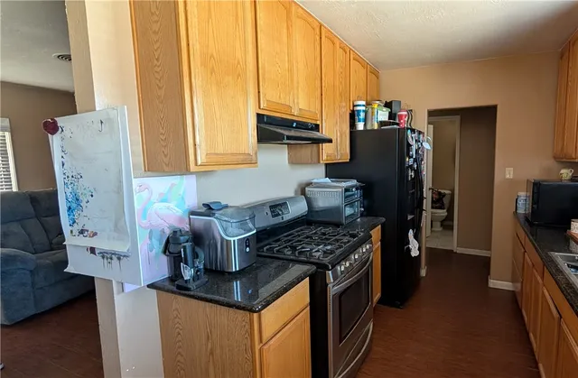 a kitchen with stainless steel appliances a stove a refrigerator white cabinets and a refrigerator