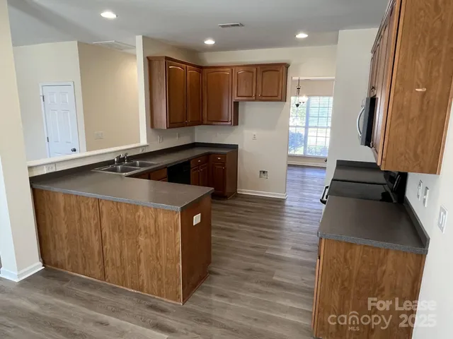a kitchen with stainless steel appliances granite countertop a stove a sink and a refrigerator