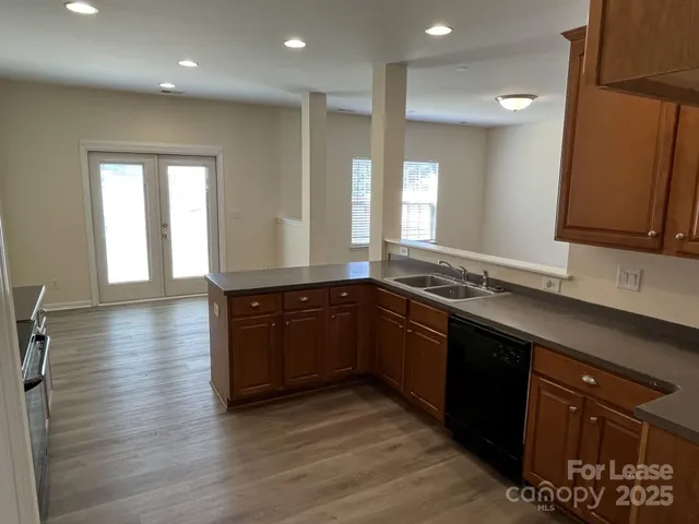 a kitchen with stainless steel appliances granite countertop a sink and wooden cabinets