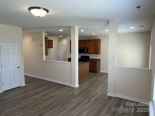a view of a kitchen with wooden floor and a refrigerator