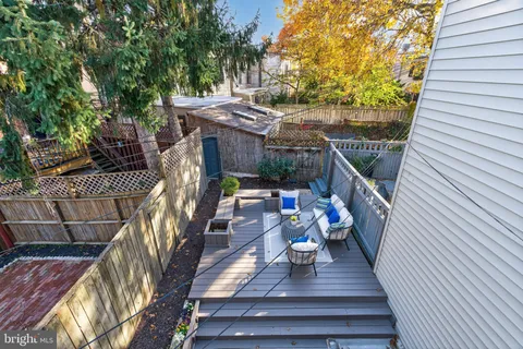 a view of a chair and table in backyard of the house