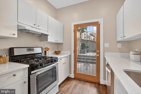 a kitchen with stainless steel appliances granite countertop a stove and a white cabinets