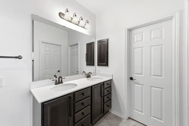 a bathroom with a double vanity sink and mirror