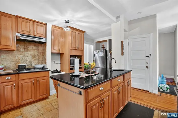 a kitchen with stainless steel appliances granite countertop a sink stove and cabinets
