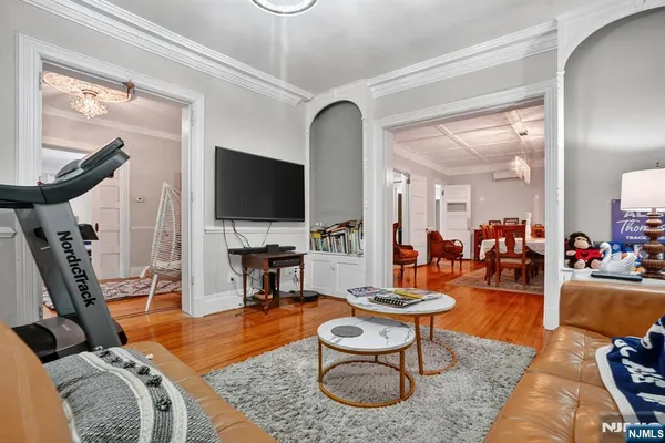a living room with furniture a flat screen tv and a floor to ceiling window