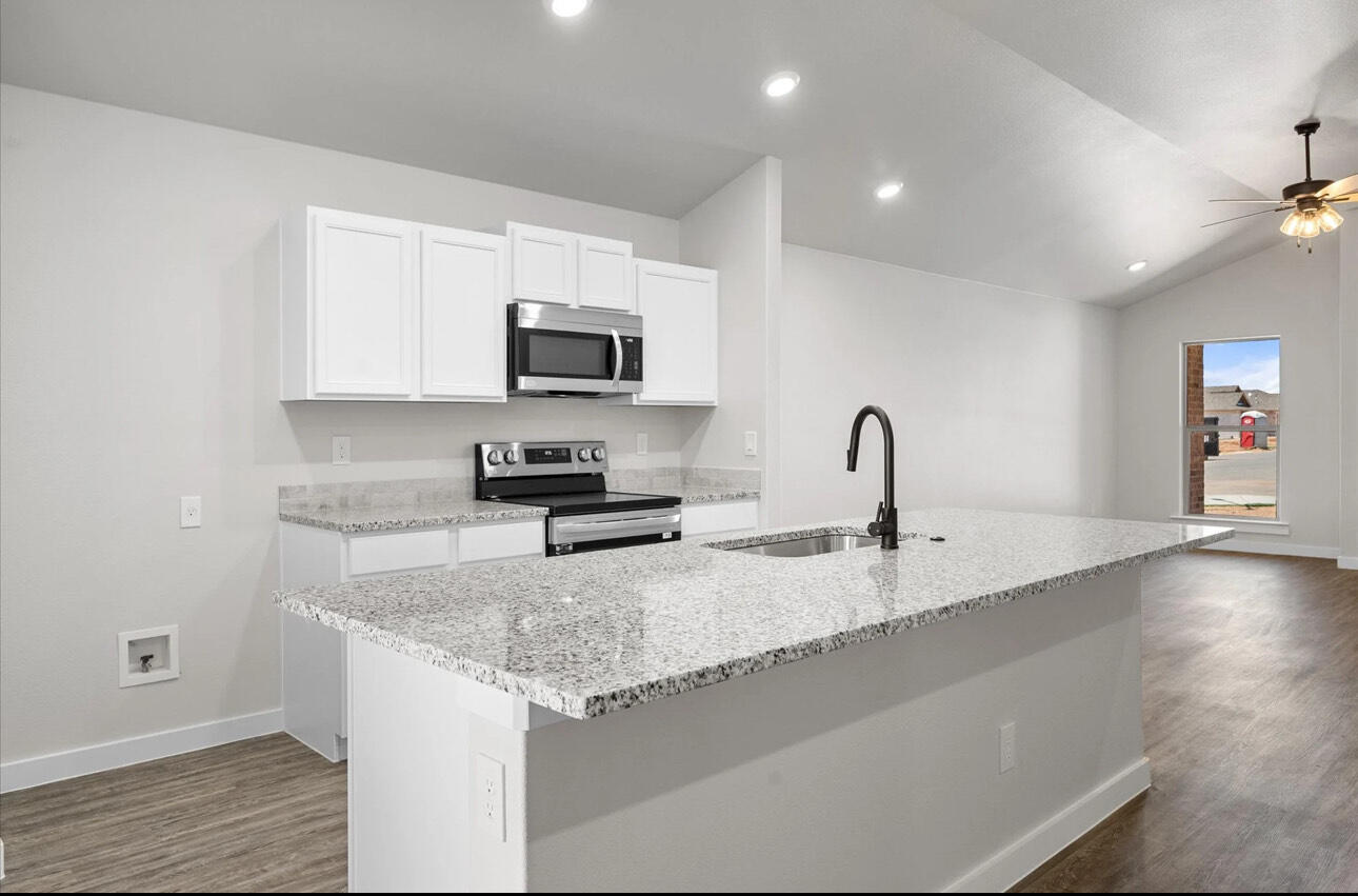 2137 Langford Avenue Lubbock, TX 79407 - Photo 7 of 12 a kitchen with granite countertop a sink and a stove top oven