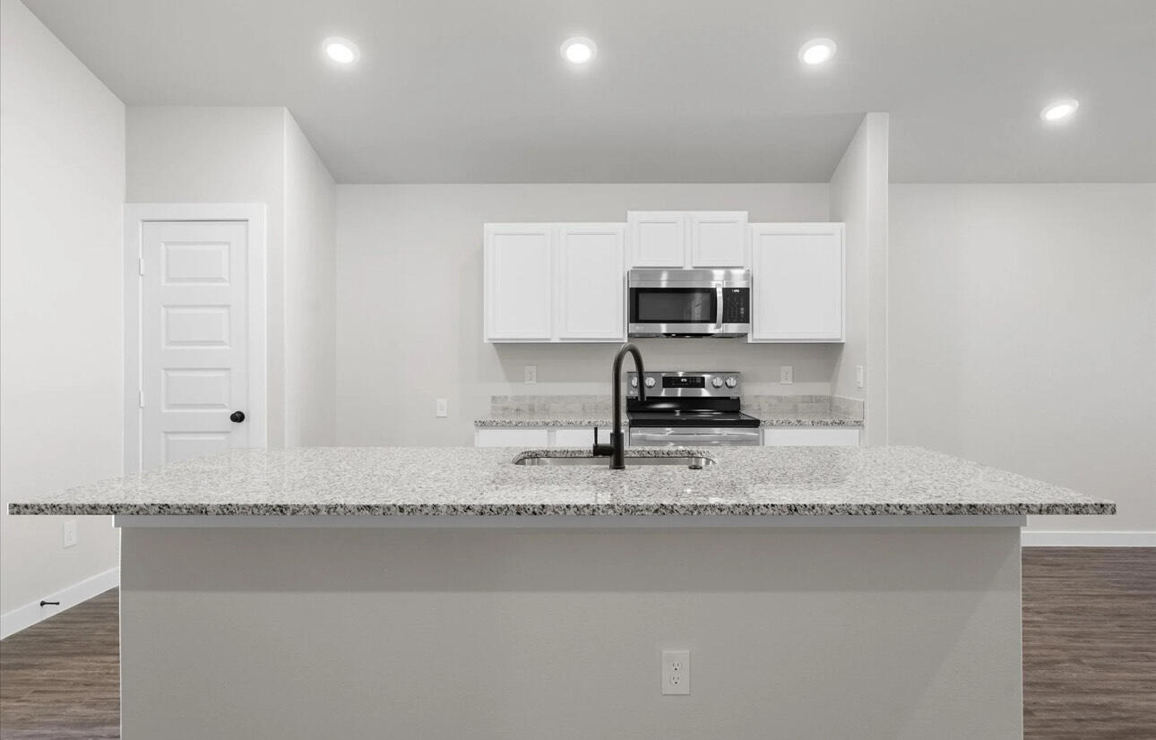 2137 Langford Avenue Lubbock, TX 79407 - Photo 8 of 12 a kitchen with a sink a stove and a microwave