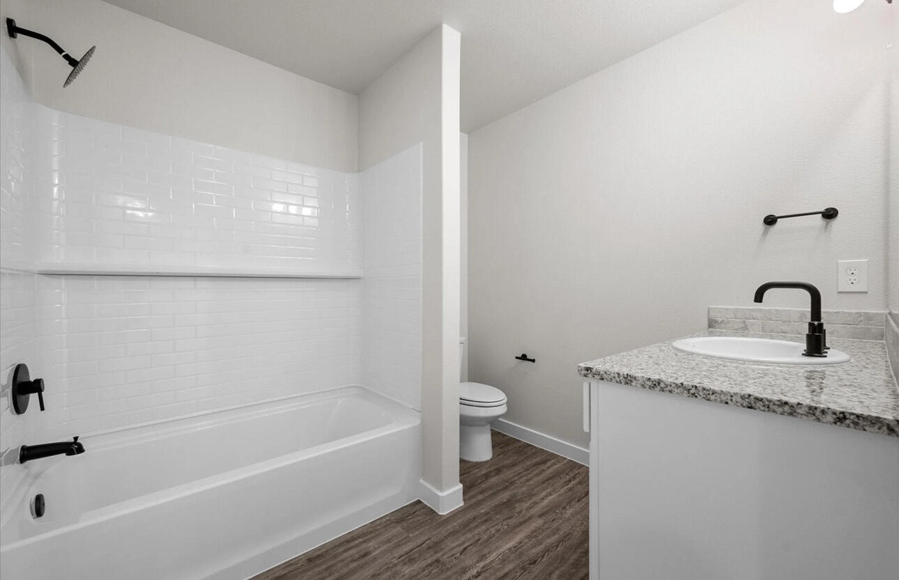 2137 Langford Avenue Lubbock, TX 79407 - Photo 10 of 12 a bathroom with a granite countertop sink a toilet and bathtub