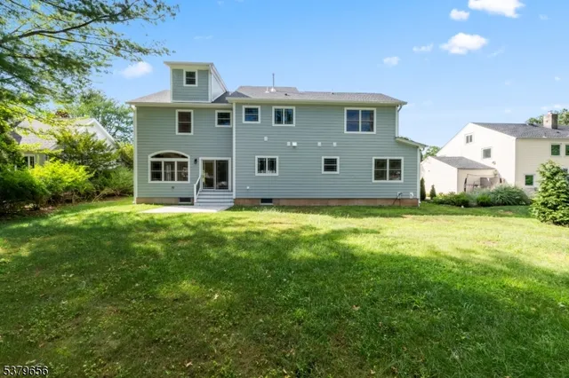 a view of a house with a big yard and large trees