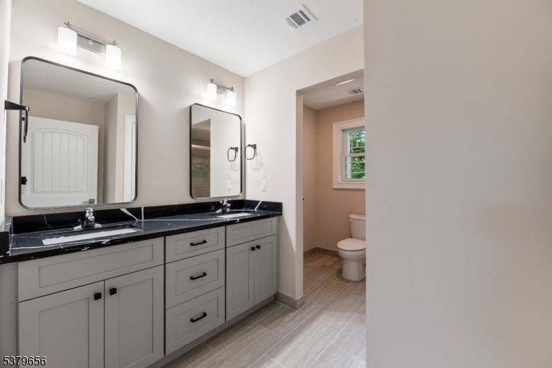 118 Cambridge Road Westfield, NJ 07090 - Photo 39 of 50 a bathroom with a granite countertop toilet sink and a mirror