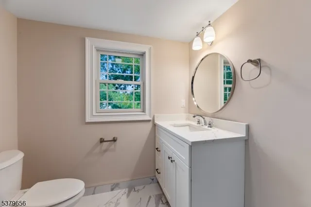 a white toilet sitting next to a bathroom sink and a shower