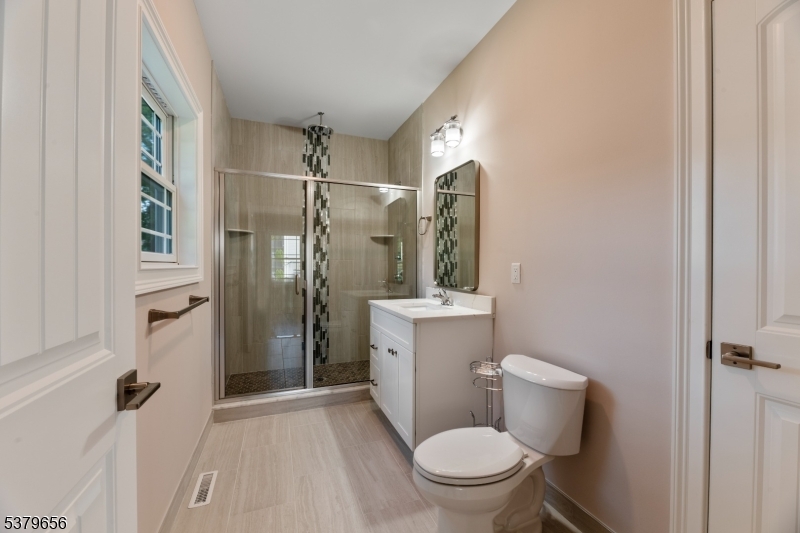118 Cambridge Road Westfield, NJ 07090 - Photo 43 of 50 a white toilet sitting next to a bathroom sink and a shower