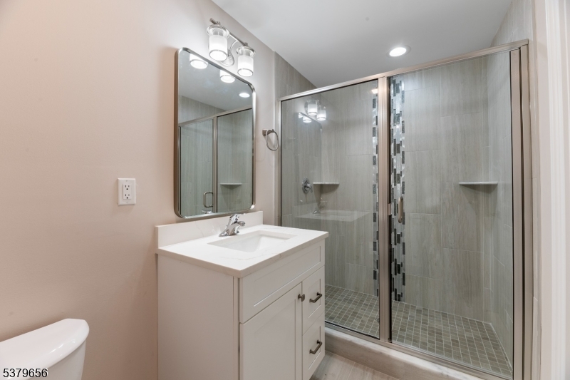 118 Cambridge Road Westfield, NJ 07090 - Photo 45 of 50 a bathroom with a shower sink vanity and mirror