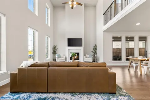 a living room with furniture a fireplace and a large window
