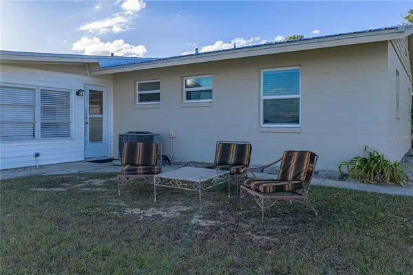 a view of a house with backyard and sitting area