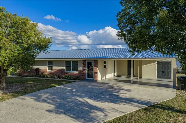 a front view of a house with yard and trees