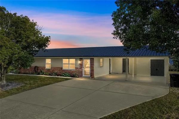 a view of a house with backyard and tree