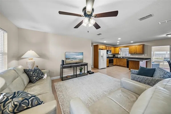 a living room with furniture and a flat screen tv with kitchen view