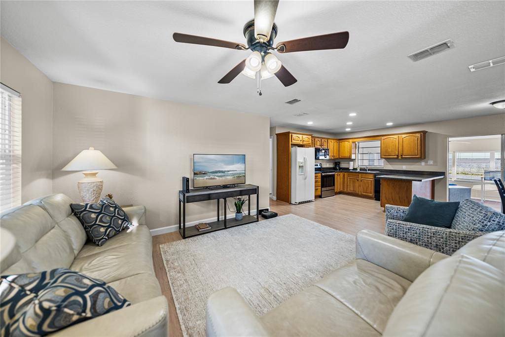 104 North Lake Reedy Boulevard Frostproof, FL 33843 - Photo 4 of 50 a living room with furniture and a flat screen tv with kitchen view