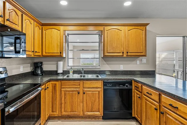 a kitchen with granite countertop wooden cabinets and a stainless steel appliances