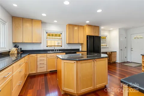 a kitchen with stainless steel appliances granite countertop a stove a sink a refrigerator and a microwave