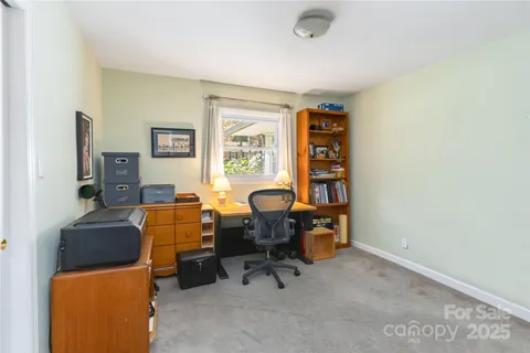 a view of a workspace with furniture and a window