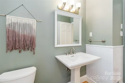 a bathroom with a sink a toilet and mirror