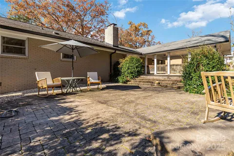 a view of a patio with table and chairs and wooden fence