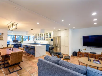 a living room with furniture a flat screen tv and kitchen view