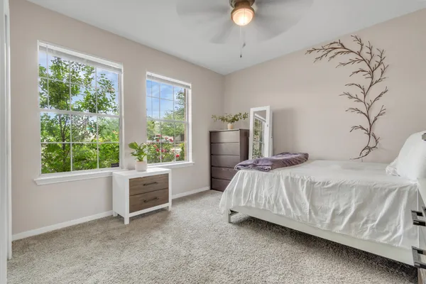 a spacious bedroom with a bed a window and a dresser